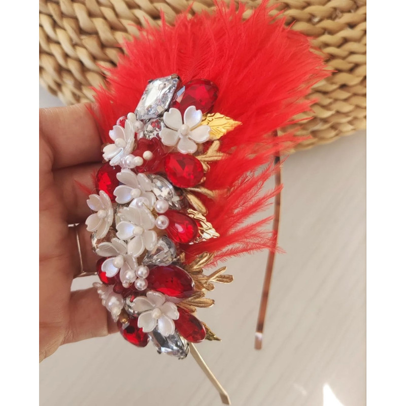 Diadema joya con plumas y piedras en tonos rojos